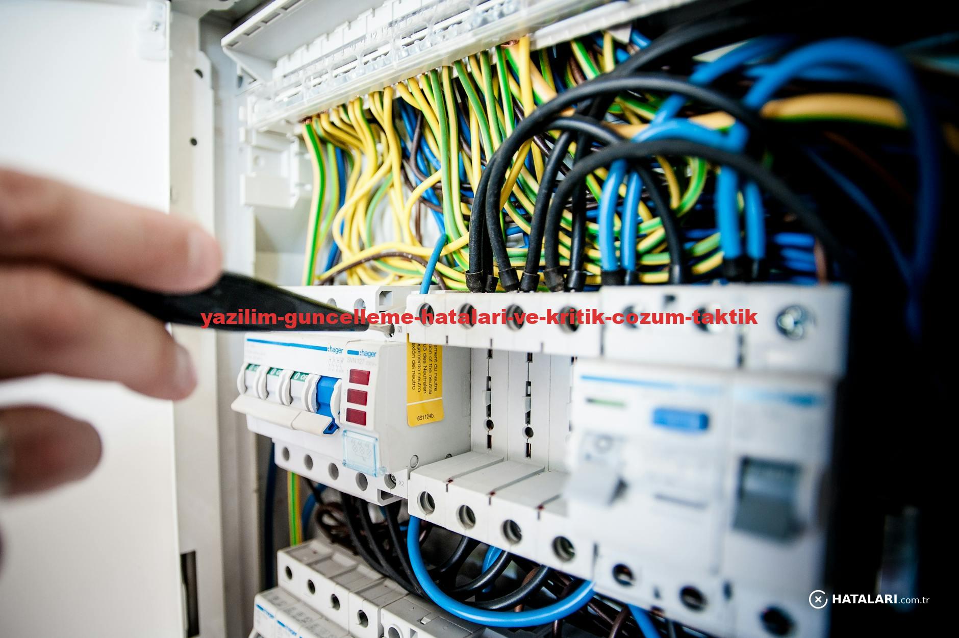 Hand of electrician working on a circuit breaker panel with colorful wires, ensuring safe electrical connections.