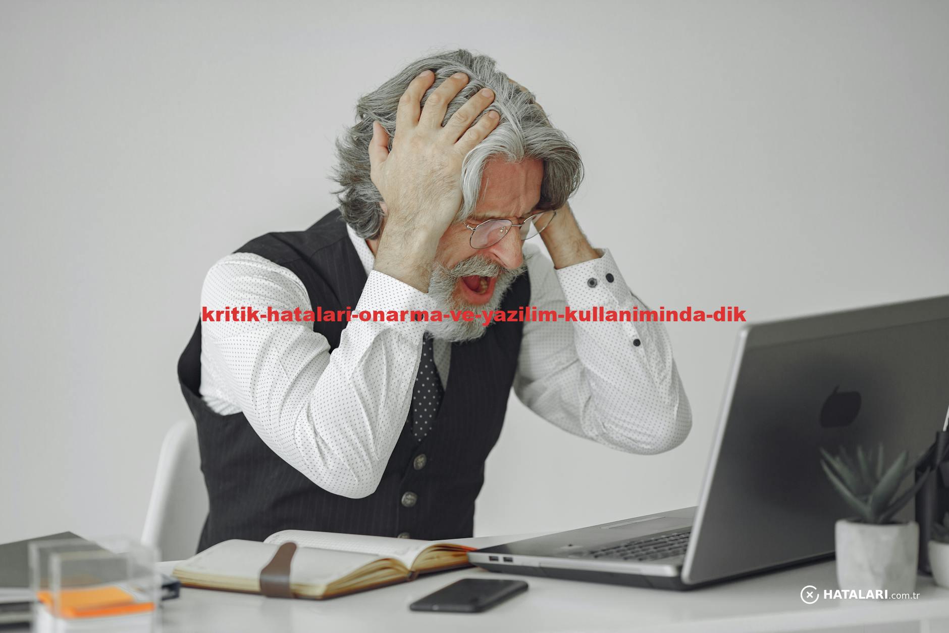 Senior businessman sitting at desk, expressing frustration with his laptop in a professional office setting.