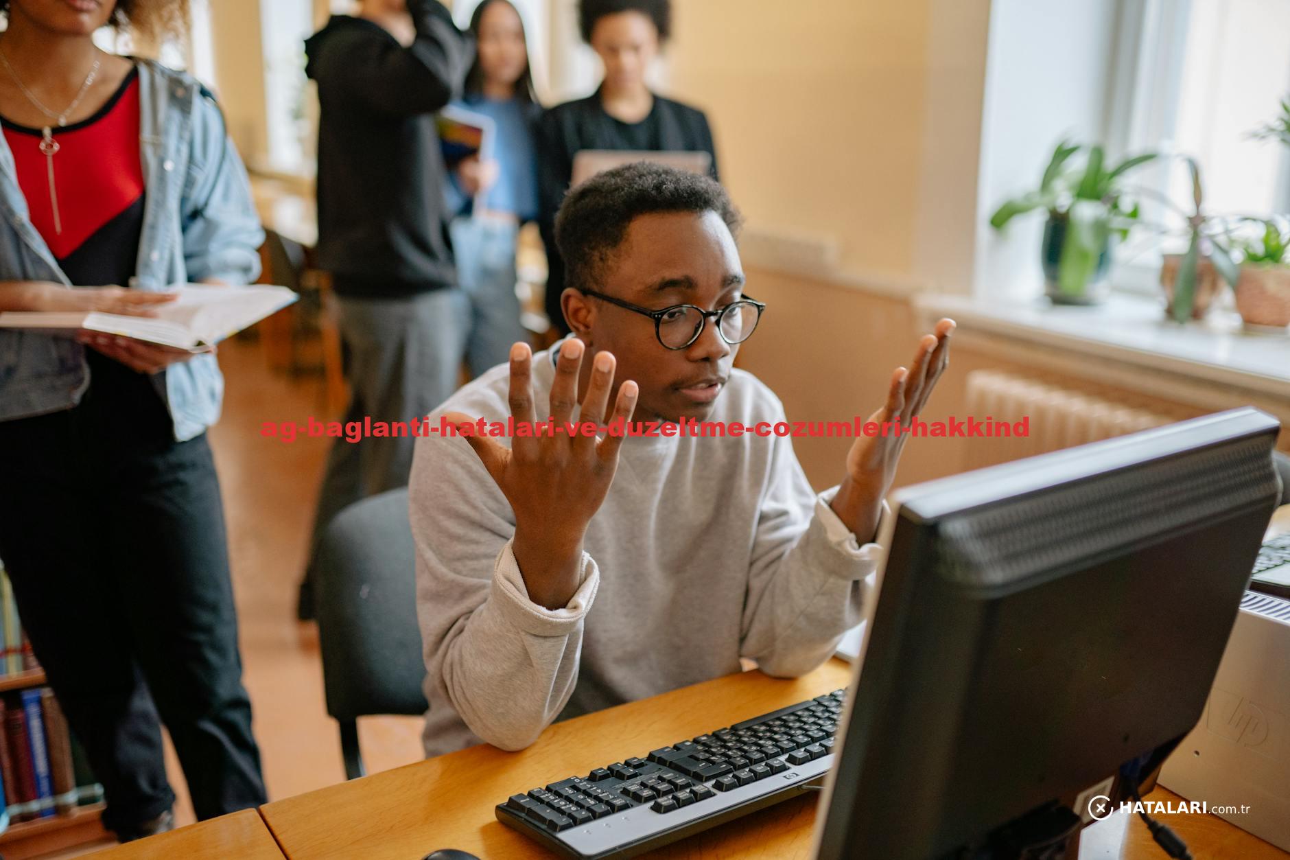 Young male office worker gesturing in frustration during a meeting at a desk.